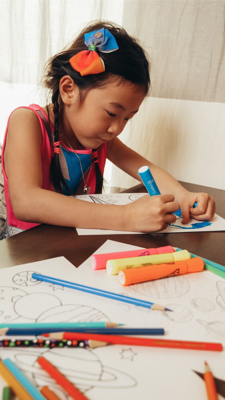 Enfant qui colorie une page avec des feutres